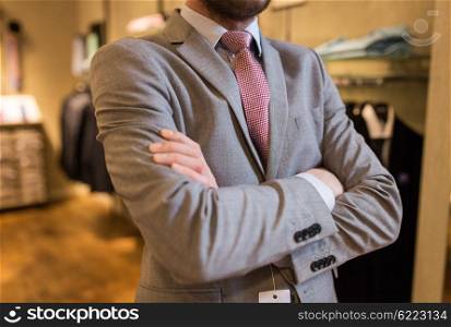 sale, shopping, fashion, style and people concept - close up of man in suit and tie at clothing store