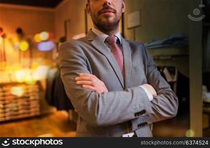 sale, shopping, fashion, style and people concept - close up of man in suit and tie at clothing store. close up of man in suit and tie at clothing store