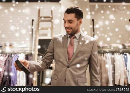 sale, shopping, fashion, style and people concept - elegant young man or businessman in suit holding little box in mall or clothing store over snow