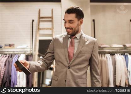 sale, shopping, fashion, style and people concept - elegant young man or businessman in suit holding little box in mall or clothing store