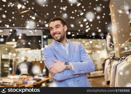 sale, shopping, fashion, style and people concept - happy young man in jacket at clothing store over snow