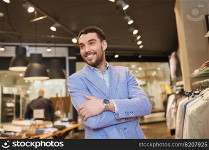 sale, shopping, fashion, style and people concept - happy young man in jacket at clothing store