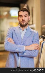 sale, shopping, fashion, style and people concept - young handsome man in jacket at clothing store