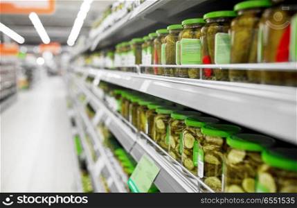 sale, shopping, food and consumerism concept - jars of pickles on grocery or supermarket shelves. jars of pickles on grocery or supermarket shelves. jars of pickles on grocery or supermarket shelves