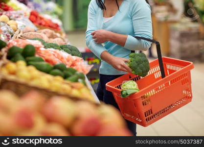 sale, shopping, food, consumerism and people concept - woman with basket buying broccoli at grocery store. woman with basket buying broccoli at grocery store