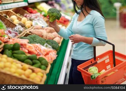 sale, shopping, food, consumerism and people concept - woman with basket buying broccoli at grocery store. woman with basket buying broccoli at grocery store. woman with basket buying broccoli at grocery store