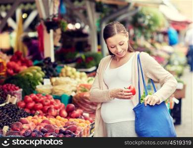 sale, shopping, food, pregnancy and people concept - happy pregnant woman buying red pepper or paprika at street market