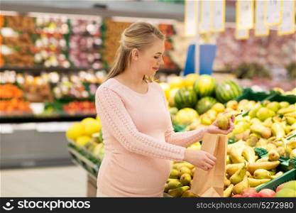 sale, shopping, food, pregnancy and people concept - happy pregnant woman buying pears and putting them into paper bag at grocery store or supermarket. pregnant woman with bag buying pears at grocery
