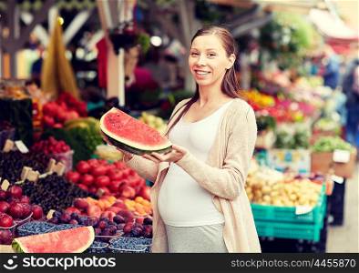 sale, shopping, food, pregnancy and people concept - happy pregnant woman choosing watermelon at street market