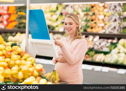 sale, shopping, food, pregnancy and people concept - happy pregnant woman weighing bananas on scale at grocery store or supermarket. pregnant woman with bananas on scale at grocery