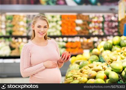 sale, shopping, food, pregnancy and people concept - happy pregnant woman with pomegranate at grocery store or supermarket. happy pregnant woman with pomegranate at grocery