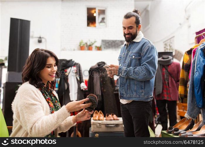 sale, shopping, footwear and people concept - happy couple choosing loafer shoes at vintage clothing store. couple choosing footwear at vintage clothing store. couple choosing footwear at vintage clothing store