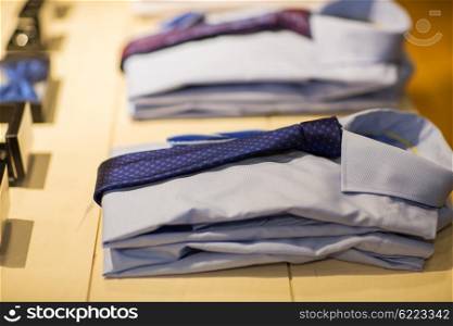 sale, shopping, male fashion, style and wear concept - close up of shirts with ties at clothing store
