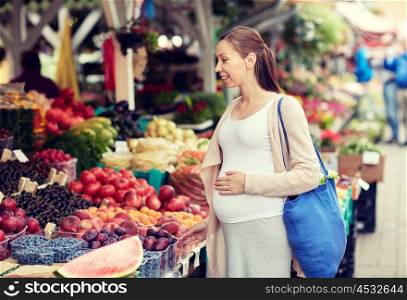 sale, shopping, pregnancy and people concept - happy pregnant woman choosing food at street market