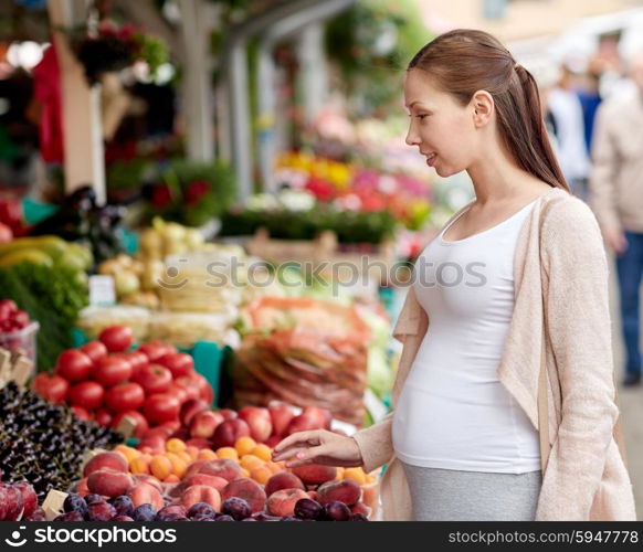 sale, shopping, pregnancy and people concept - happy pregnant woman choosing food at street market