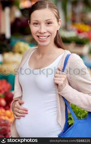 sale, shopping, pregnancy and people concept - happy pregnant woman with bag at street market
