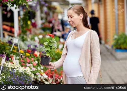 sale, shopping, pregnancy, gardening and people concept - happy pregnant woman choosing flowers at street market