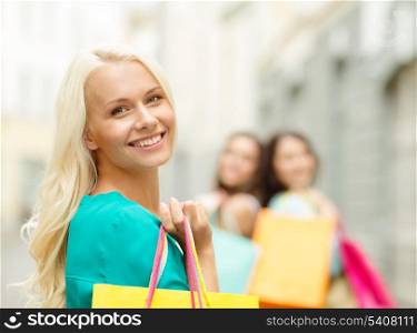 sale, shopping, tourism and happy people concept - beautiful woman with shopping bags in the ctiy