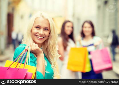 sale, shopping, tourism and happy people concept - beautiful woman with shopping bags in the ctiy