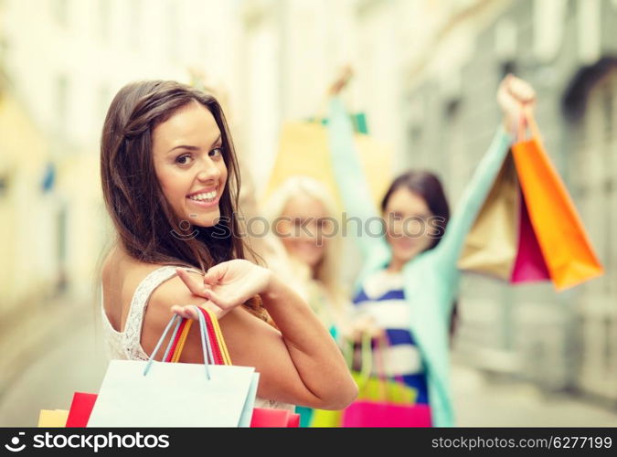 sale, shopping, tourism and happy people concept - beautiful woman with shopping bags in the ctiy