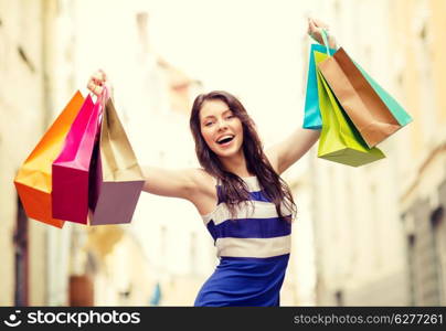 sale, shopping, tourism and happy people concept - beautiful woman with shopping bags in the ctiy