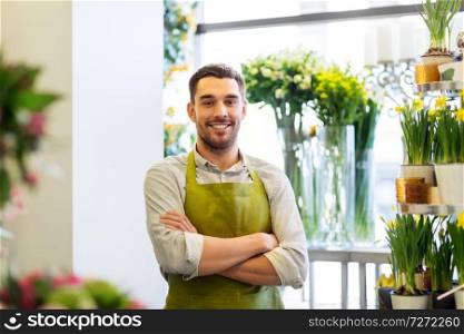 sale, small business and floristry concept - happy smiling florist man or seller at flower shop. florist man or seller at flower shop counter