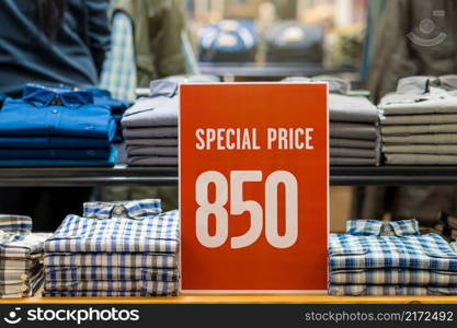 sale special price mock up advertise display frame setting over the stack of shirt in the shopping department store for shopping, business fashion and advertisement concept