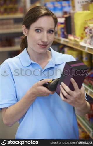 Sales Assistant Checking Stock Levels In Supmarket Using Hand Held Device