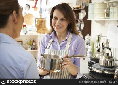 Sales Assistant In Homeware Shop Showing Customer Pan