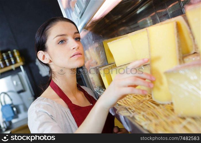 sales clerk at the dairy counter choosing cheese
