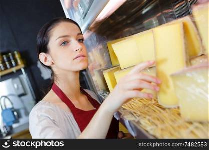 sales clerk at the dairy counter choosing cheese