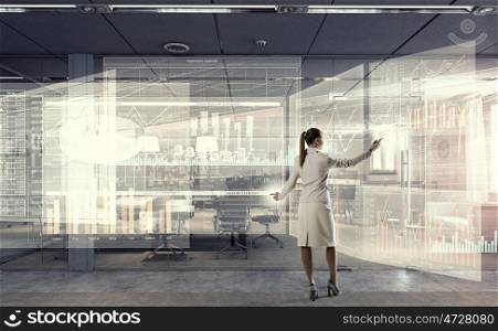 Sales dynamics report mixed media. Elegant businesswoman in modern office drawing infographs