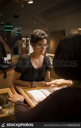 Sales girl at jewelry store helping customer