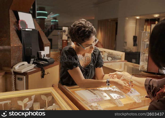 Sales girl at jewelry store helping customer