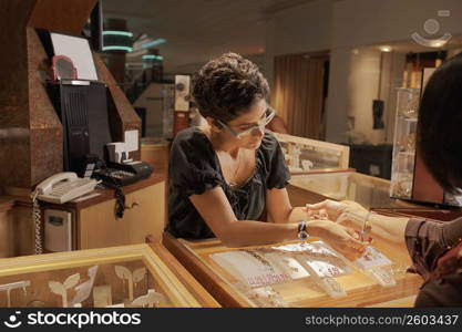 Sales girl at jewelry store helping customer