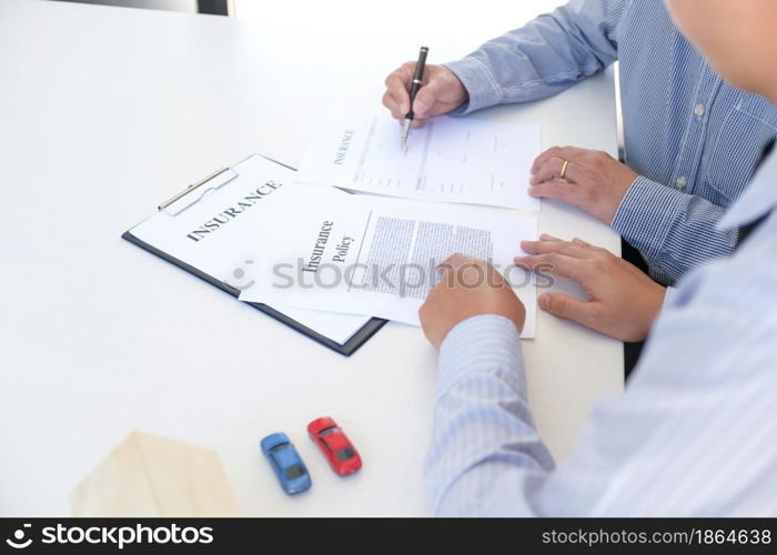 Sales manager giving advice application form document, considering mortgage loan offer for car and house insurance