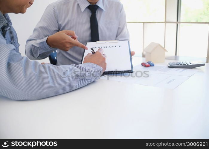 Sales manager giving advice application form document, considering mortgage loan offer for car and house insurance