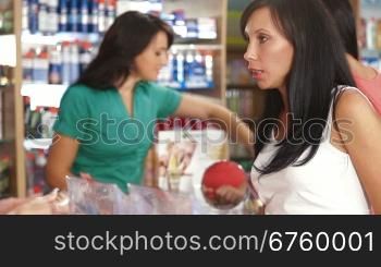 Sales Person Assisting Female Shopper in Choice of Beauty Care Products