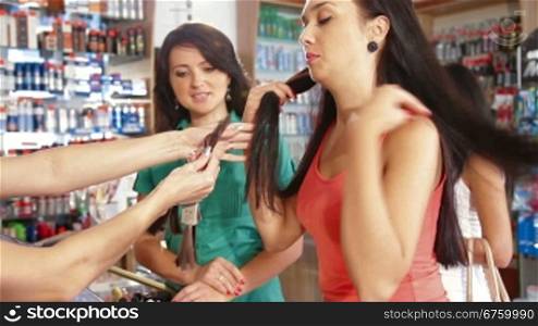 Sales Person Assisting Female Shoppers in Choice of Hair Dye