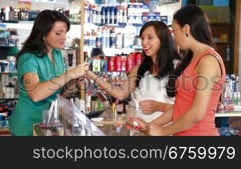 Sales representative advising a young woman in a choice of make-up foundation