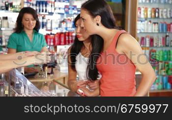 Sales representative advising a young women in a choice of cosmetics