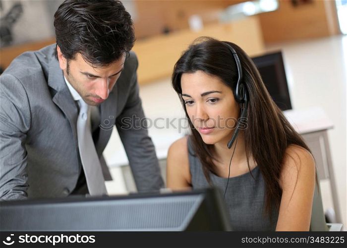 Sales representative with manager in front of desktop