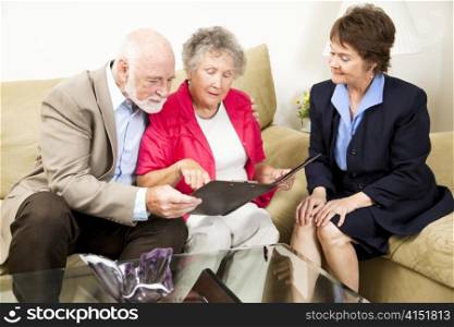 Sales woman looks on as a senior couple considers her product information.