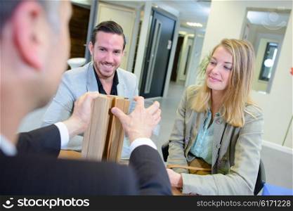 Salesman demonstrating materials to couple