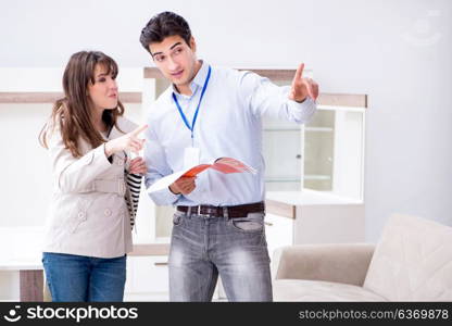 Salesman explaining to woman customer at furniture store