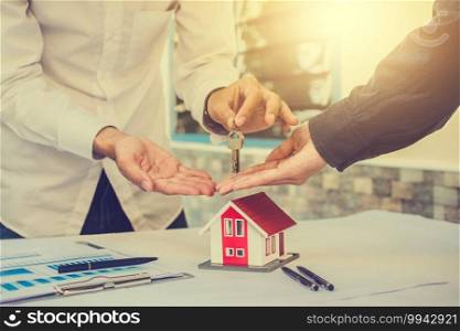 Salesman giving key house to customer in concept business loan finance investment family rent insurance