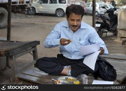 Salesman having lunch and looking into paper work