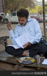 Salesman having lunch and looking into paper work