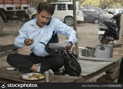 Salesman having lunch and using cell phone