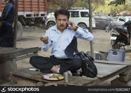 Salesman having lunch and using cell phone